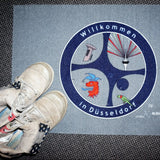 Hochwertige Fußmatte mit dem Motiv „Willkommen in Düsseldorf“ und dem Radschläger-Symbol. Robuster Türvorleger für Privatkunden und Unternehmen.