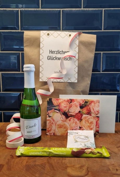 B2B Wundertüte Genusstüte zum Geburtstag mit Rauten-Etikett und Logo, hier mit Sekt mit Danke-Etikett und schöner Grußkarte